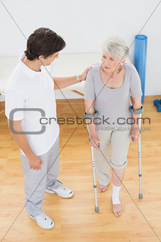 Male therapist in discussion with a disabled senior patient