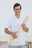 Portrait of a smiling doctor holding skeleton model