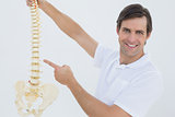 Portrait of a smiling male doctor with skeleton model
