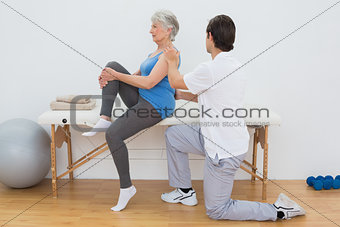 Male physiotherapist examining senior woman's back