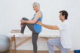 Male physiotherapist examining senior woman's back