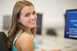 Pretty student smiling at camera in the computer room