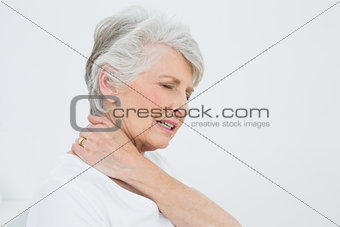 Side view of a senior woman suffering from neck pain