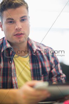 Handsome student working in the computer room looking at camera