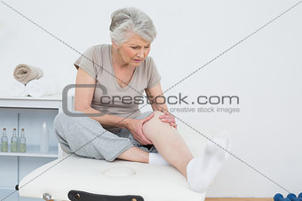 Senior woman with her hands on a painful knee