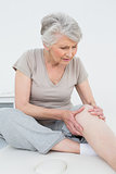 Senior woman with her hands on a painful knee