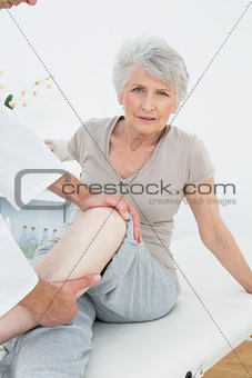 Portrait of a senior woman getting her leg examined