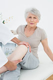 Portrait of a senior woman getting her leg examined