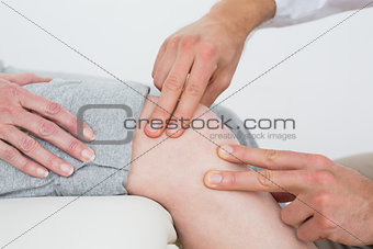 Mid section of a woman getting her knee examined