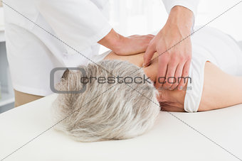 Physiotherapist massaging a senior woman's back