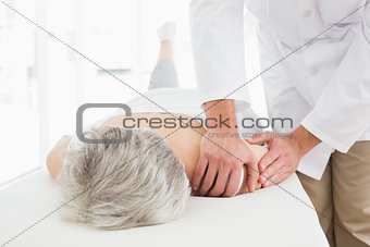 Physiotherapist massaging a senior woman's shoulder