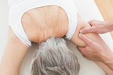 Physiotherapist massaging a senior woman's arm