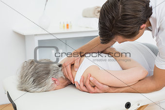 Male physiotherapist examining a senior woman's hand