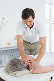 Physiotherapist massaging a senior woman's shoulder