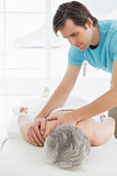 Physiotherapist massaging a senior woman's back