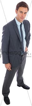 Stern businessman standing with hand on hip