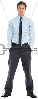 Serious businessman standing with hands in pockets