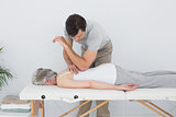 Male physiotherapist massaging a senior woman's back