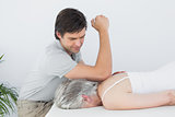 Male physiotherapist massaging a senior woman's back
