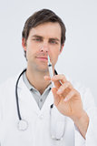 Portrait of a handsome male doctor holding an injection