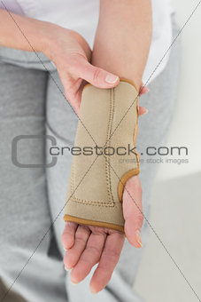 Close-up mid section of a woman with hand in wrist brace