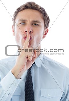 Businessman with finger on lips