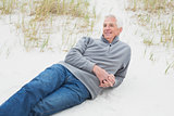 Smiling casual senior man relaxing at beach