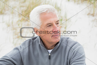Smiling casual senior man relaxing at beach