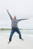 Full length of a senior man jumping at beach