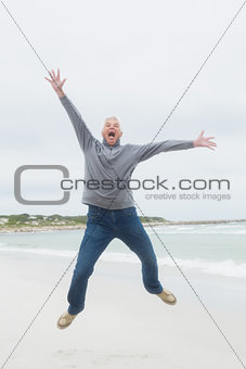 Full length of a senior man jumping at beach
