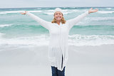 Casual senior woman with arms outstretched at beach