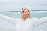 Senior woman with arms outstretched at beach