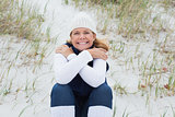 Happy senior woman feeling cold at beach