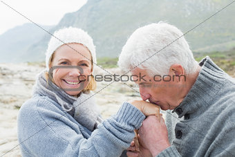 Senior man kissing happy woman's hand