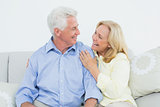 Cheerful loving senior couple sitting on sofa