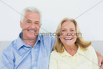 Cheerful loving senior couple sitting on sofa