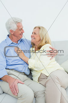 Happy romantic senior couple sitting on sofa