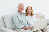Relaxed loving senior couple using laptop