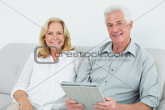 Relaxed senior couple with digital tablet at home