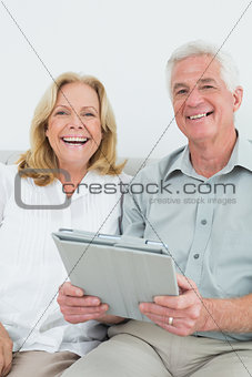 Senior couple with digital tablet at home