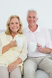 Senior couple with coffee cups at home