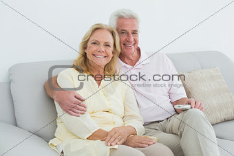 Relaxed happy senior couple with remote control at home