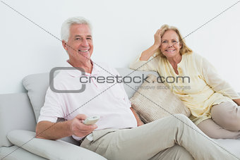 Senior couple with remote control at home