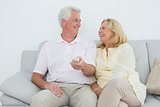 Cheerful senior couple watching television
