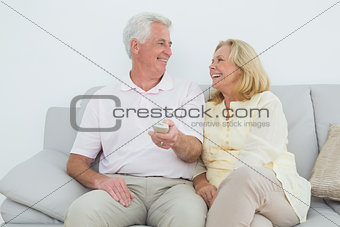 Cheerful senior couple watching television