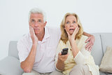 Shocked senior couple watching television