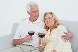 Relaxed senior couple with wine glasses at home