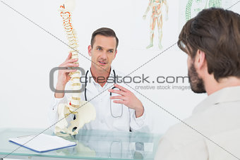 Male doctor explaining the spine to a patient