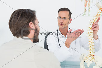 Male doctor explaining the spine to a patient