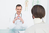 Friendly doctor listening to patient with concentration at desk